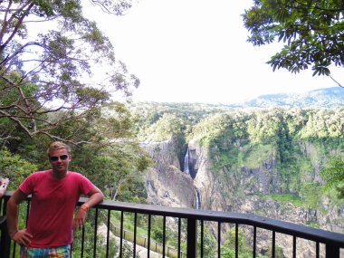 Barron Falls viewing platform with German blonde man in colorful shorts and pink t-shirt Australia. High quality photo clipart