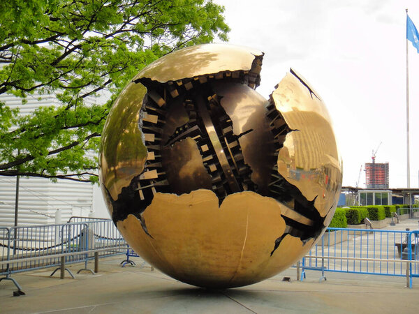 Художественное изображение золотой сферы с круглым отверстием, напоминающим небо или навес дерева. Отражает симметрию и природные материалы в творчестве