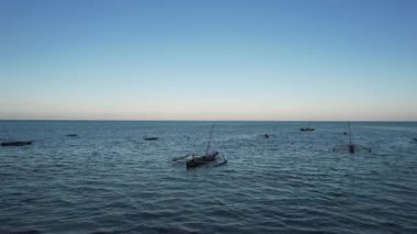 Güzel bir Jambiani Zanzibar Drone görüntüsü mavi bir günbatımı gökyüzü altında, bazı Afrika balıkçı tekneleri, gökyüzü ve doğal manzara ile yüksek gelgit sularının güzelliğini sergiliyor.