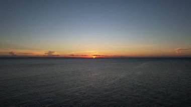 Atmosferik bir görüntü, sakin bir günbatımının güzelliğini yakalar okyanusun sakin sularına yansıtarak, karanlık gökyüzünde rüya gibi bir parıltı yaratır Nungwi Kendwa Zanzibar Drone Tanzanya 'yı görür