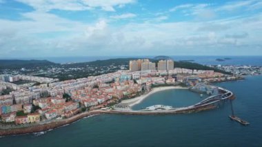 Güneşli bir günde, gök mavisi okyanusun kenarındaki canlı bir şehrin büyüleyici hava manzarası. Kıyı zeminine karşı kentsel binalar çarpıcı bir şehir manzarası yaratır İtalyan köyü Phu Quoc adası Vietnam