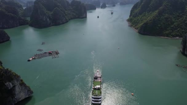 雄大な山々に囲まれた大きな水の上を航海するボートは 自然の風景ハロンベイハノイベトナムで沿岸と海洋の風景の美しさを示しています — ストック動画