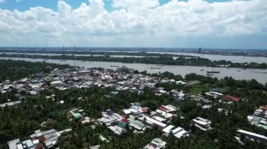 Etrafı yeşilliklerle çevrili, sakin bir nehirle çevrili kentsel ve doğal elementlerin resimli bir manzara olan Mekong Delta Nehri 'ndeki karışımını aydınlatan büyüleyici bir hava manzarası