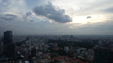 Gün batımında gökyüzünde bulutların rengarenk bir atmosfer yarattığı bir şehir manzarası. Kule blokları ve binalar ufuk çizgisinde Ho Chi Minh Şehri Vietnam 'ın aşağısındaki suya yansıyor.