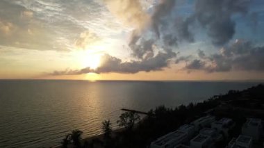 Güneş okyanusun üzerinde batıyor, bulutlarla gökyüzünü boyuyor, tıpkı suyun solan ışığı yansıttığı gibi. Phu Quoc Adası Long Beach Vietnam 'da sakin doğal bir manzara.