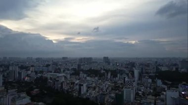 Yüksek binalar, su kütleleri ve bulutlu gökyüzü manzarada dramatik bir atmosfer yaratıyor.