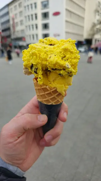 Persoon Heeft Een Zonnige Gele Bevroren Dessertkegel Gemaakt Van Zuivel Stockfoto