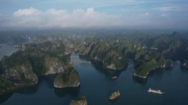 Gökyüzündeki tüylü kümülüs bulutlarını yansıtan dingin suyla yükselen yüksek dağların arasına yerleşmiş pitoresk bir göl. Hanoi 5K, Halong Bay Vietnam Asya manzarası.