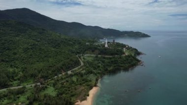 Gökyüzünden görünen plajı, dağları ve suyu olan pitoresk bir doğal manzara. Gökyüzü kabarık bulutlarla dolu. Huzurlu ve nefes kesici bir manzara yaratıyor. Da Nang Vietnam Asya 'nın 5K görüntüsü.