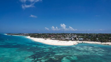 Uçsuz bucaksız okyanuslarla çevrili küçük bir Zanzibar adasını görüntüler. Sahne su, bulutlar, gökyüzü, doğal manzara, Kendwa plajı, seyahat, rüzgar dalgaları ve kümülüs bulutlarını içerir. Afrika