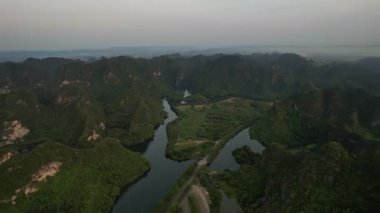 Dağların ve ağaçların arasından akan bir nehrin yer aldığı, bulutlardan oluşan bir zemin ve gökyüzü olan Binh dışı Vietnam 5K insansız hava aracı manzaralı doğal bir manzara.
