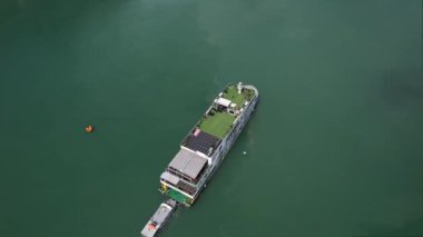 Sıvı suyun üzerinde yüzen bir su aracının havadan görünüşü, Halong Körfezi Hanoi Vietnam 'ın 5K' lık deniz ortamındaki mühendislik harikalarını gözler önüne seriyor.