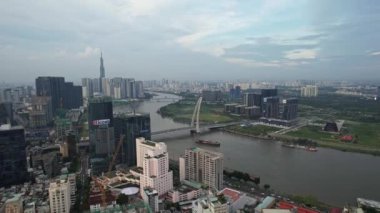 Şehir manzarası, içinden nehir geçen, gökdelenler ve gökdelenlerle şehir tasarımının bir karışımını gösteren, bulutlu bir gökyüzünün arka planına karşı kule blokları.