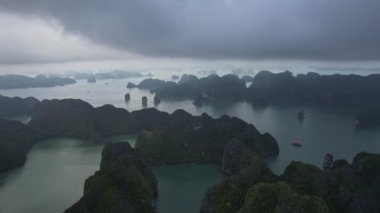 Suyun bulutlu gökyüzünü yansıttığı güzel bir doğal manzara, gölün etrafını saran dağlar, Halong Körfezi Hanoi Vietnam 'ın 5K dönüşlü manzarasını oluşturur.