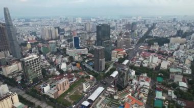 Yükselen gökdelenleri, yeşillikleri ve gökyüzünden yakalanan yoğun trafiği olan hareketli bir şehir. Şehir manzarası canlı, konut alanları ve ticari binalar karışımı Ho Chi