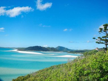 Whitehaven Sahili, Queensland, WhitSunday Adası 'ndaki ağaçlarla çevrili pitoresk bir tepenin ötesine uzanan uçsuz bucaksız okyanusun nefes kesici bir görüntüsü.