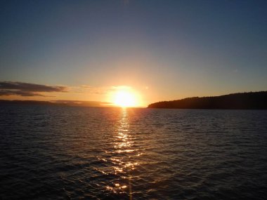 Gün sona ererken, güneş zarif bir şekilde alçalır ve sıcak parıltısını Whitsunday Adası, Queensland, Avustralya 'da akşam olmadan önce suyun sakin gövdesine saçar.