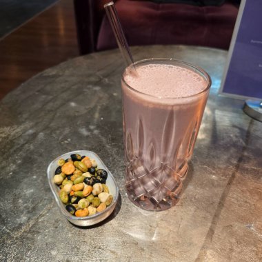 Lezzetli bir içecek, canlı, renkli bir aperatif kombinasyonuyla servis edilir.