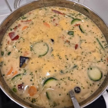 Lezzetli ve kremalı bir sebze çorbası. Sobanın üzerinde yavaşça kaynayan bir dizi renkli malzemeyle birlikte.