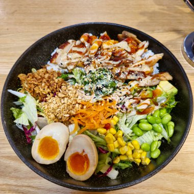 Izgara tavuk, taze sebzeler ve leziz malzemelerle dolu canlı ve renkli bir pirinç kasesinin tadını çıkarın.