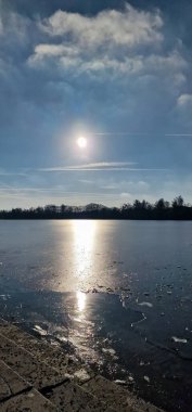 Büyüleyici bir günbatımı, sakin sulara yansıyor. Resmedilmiş bulutlar ve doğal güzellikler. Hanover Maschsee. 