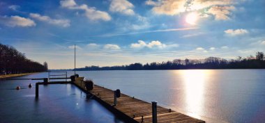 Güzel, sakin bir göl manzarası berrak, parlak bir su sergiliyor canlı, renkli gökyüzü Hanover Maschsee 'nin yanında.