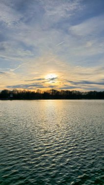 Huzurlu bir günbatımı parlıyor ve sakin sulara yansıyor. Muhteşem bir rahatlama için mükemmel bir sahne yaratıyor. Hanover Maschsee.