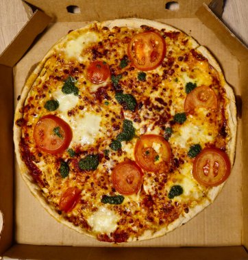 Taze domates, şifalı ot ve fesleğenle kaplı lezzetli bir pizza. Tek başına yemek ya da zevk almak için ideal.