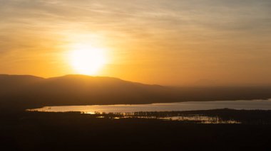 Nefes kesici bir günbatımı görkemli dağları ve yansıtıcı suları aydınlatıyor. Manyara Gölü Tanzanya Afrika 'sı için ideal.
