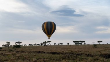 Nefes kesici bir sıcak hava balonu, Afrika üzerindeki Serengeti Tanzanya Afrika 'nın engin gökyüzünde huzur içinde süzülür.