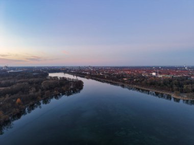 Havadan çekilen görüntüler, sakin bir nehrin sakin bir şehir manzarası tarafından sakin bir gökyüzünün altında aktığını gösteriyor. Maschsee Hannover.