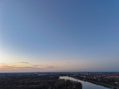 Göz kamaştırıcı manzaralı bir hava görüntüsü, Maschsee Hannover 'ın günbatımında canlı bir şehir manzarası boyunca zarifçe kıvrılan bir nehri tasvir eder.