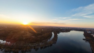 Nefes kesici bir hava manzarası canlı bir günbatımını güzel bir şekilde yansıtan sakin bir nehrin doğası Maschsee Hannover ile çevrili.