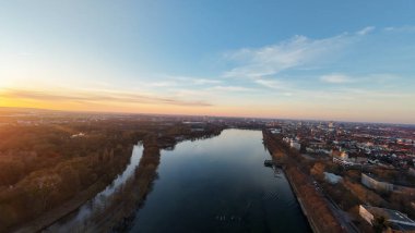 Kıvrımlı bir nehir ve canlı bir şehir üzerinde çarpıcı bir günbatımına tanıklık edin. Doğanın ve kentsel yaşamın uyumu Maschsee Hannover 'ın