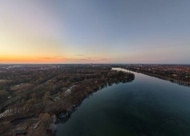 Bu gün batımında sakin bir nehri yakalayan çarpıcı bir hava manzarası. Doğanın nihai güzelliğini ve huzurunu gözler önüne seriyor. Maschsee Hannover.