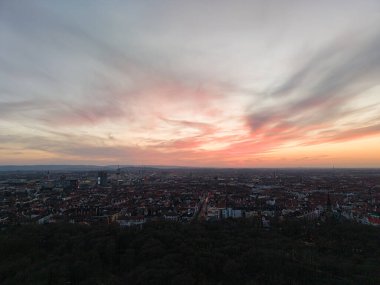 Hannover Listesi Düşük Saksonya 'nın genişleyen şehir silueti üzerinde çarpıcı renkler bırakan canlı bir günbatımını gösteren nefes kesici bir manzara