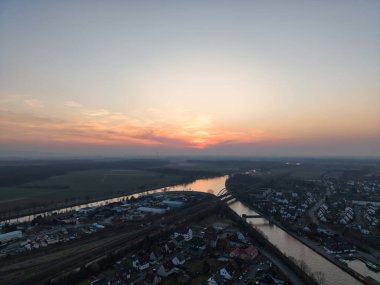 Nefes kesici bir hava manzarası serin bir nehir yüzeyi olan Hannover Seelze 'e yansıyan çarpıcı günbatımını yakalıyor.