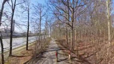 Huzurlu ve sakin bir patika, açık mavi gökyüzü Mittellandkanal Hannover Kinderwald 'ın altında çıplak ağaçlarla çevrili, nazikçe akan bir nehrin yanında esiyor.