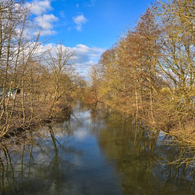 Huzurlu nehir, bereketli bir ağaç koruluğunun içinden huzurlu bir şekilde akar. Güzelce sergilenen sonbahar renkleri Maschsee Hannover.