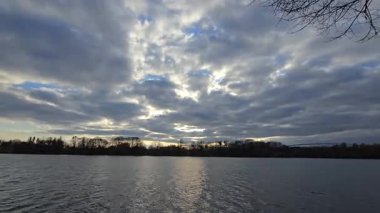 Huzurlu bir göl manzarası, Maschsee Hannover 'ın büyülü alacakaranlık saatlerinde durgun suya yansıyan renkli hiperhız bulutlarını gösteriyor.