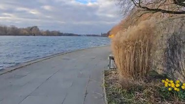 Muhteşem suyu, yemyeşil otları ve Maschsee Hannover 'ın yumuşak bulutlarını gösteren güzel ve sakin bir nehir manzarası.
