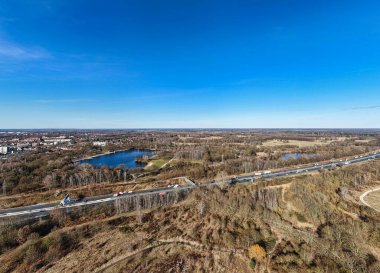 Çarpıcı bir hava manzarası, kıvrımlı yollar ve sakin su cisimlerinin yer aldığı canlı bir manzara sergiliyor. Hannover Langenhagen Silbersee