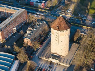 Çarpıcı bir hava perspektifi çağdaş binalar ve manzaralar arasında tarihi bir kuleyi gözler önüne seriyor. Akşamdan Kalma Wasserturm