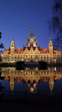 Büyüleyici bir gece sahnesi, sakin ve huzurlu Maschpark Hannover nehrine yansıyan tarihi bir binayı güzellikle gözler önüne seriyor.