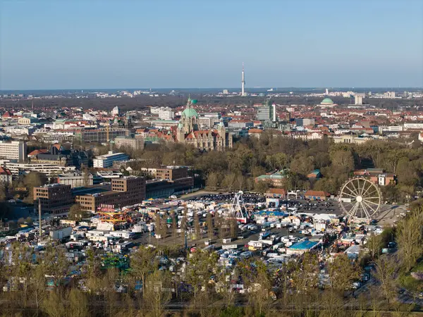 Canlı Hannover Bahar Festivali 'nin hava manzarasında şehrin ikonik siluetine karşı bir dönme dolap yer alıyor.