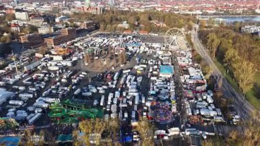 Heyecan verici geziler, çeşitli tezgahlar ve Hanover Bahar Festivali Maschsee 2025 'in hareketli aktiviteleriyle dolu canlı bir panayır manzarası.