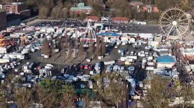 Schutzenfest Hannover İlkbahar Festivali 2025 'in dört bir yanında geniş bir dönme dolap ve sayısız canlı satıcı tezgahları sergilenen hareketli bir panayır sahnesi.