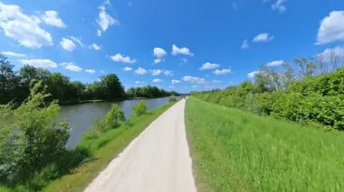 Bu dingin nehir kenarı yolu sakin yürüyüşler, bisikletler ve açık mavi gökyüzü altında doğanın tadını çıkarmak için idealdir.