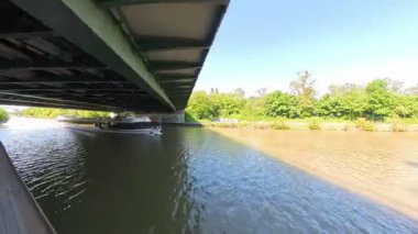 Büyüleyici bir köprünün altında süzülen teknelerle dolu manzaralı nehir manzaraları, canlı, yemyeşil Hannover Mittellandkanal