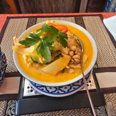 Renkli bir kase Tayland hindistan cevizli tavuk körisi, taze otlar ve fıstıkla süslenmiş Hannover 'da keyifli bir deneyim için.